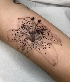 a black and white photo of a flower on the left arm, with dots all over it