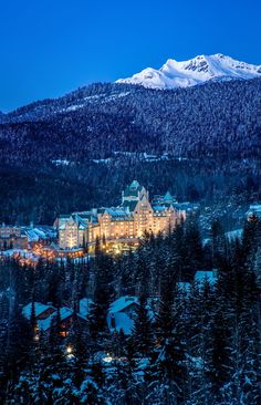 a large building surrounded by snow covered mountains