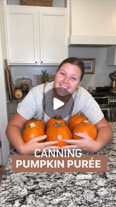 a woman holding pumpkins in her hands with the words canning pumpkin puree on it