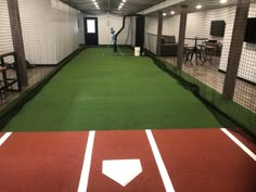 an indoor baseball field with batting cages and tables