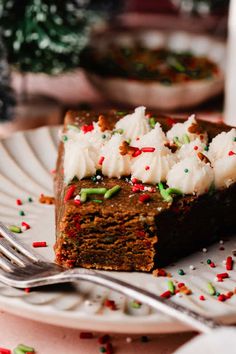 a piece of cake on a white plate with sprinkles and frosting