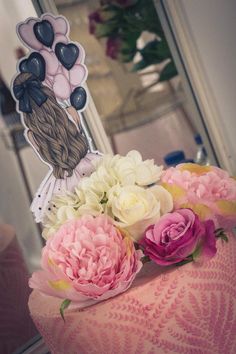 pink and white flowers are sitting on top of a hat