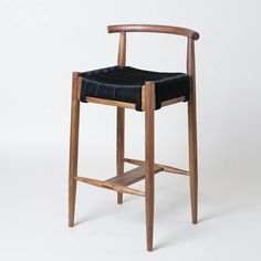 a wooden chair with a black leather seat and back rest on a white background,