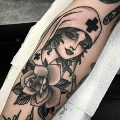 a woman's arm with a cross on it and roses in the corner,