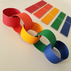 several different colored paper bracelets sitting on top of a white table next to each other