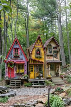 three colorful houses in the woods surrounded by trees