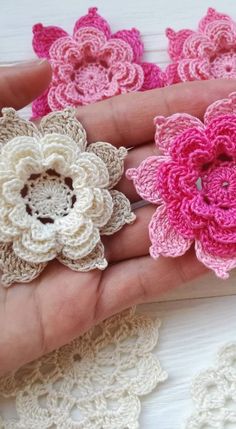 crocheted flowers are being held in someone's hand