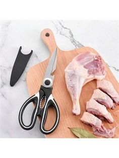 a cutting board with meat and scissors on it