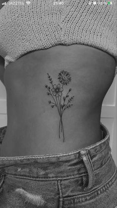 a woman's stomach with a flower tattoo on her lower back, and the bottom half