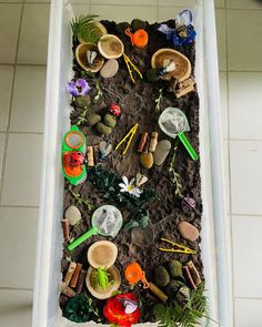 a white tub filled with lots of toys and dirt