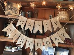 a happy birthday banner hanging on a shelf in a room with pictures and other items