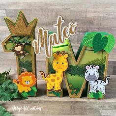 the letters m are made out of paper and have animals on them, including a giraffe