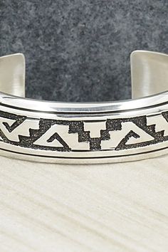 This sterling silver bracelet featuring a traditional Navajo pattern was made by Navajo silversmith Rosita Singer. The back is signed T&R Singer and stamped sterling.Size: 5 1/2" (will fit a 6 3/4" wrist)Gap: 1 1/4"Length: 3/4"Free shipping on all orders! We ship with USPS and always include tracking. All orders ship within a day of payment.Returns are accepted up to 30 days after you receive your order. Just send us a message. Our shop offers cash back or store credit. The item must be returned Southwestern Silver Cuff Bracelet With Inlay, Silver Stamped Southwestern Bracelets, Silver Southwestern Stamped Bracelets, Sterling Silver Inlay Bracelets In Silver Color, Adjustable Sterling Silver Western Bracelet, Adjustable Silver Bangle With Inlay, Southwestern Stamped Silver Bracelets, Southwestern Style Etched Sterling Silver Bracelet, Western Style Adjustable Sterling Silver Bracelet