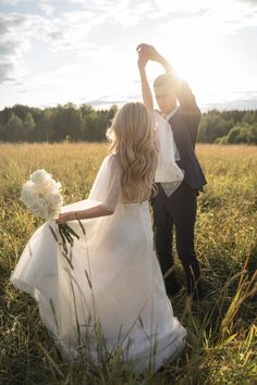 a bride and groom standing in the middle of a field