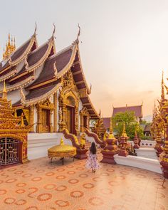 a woman standing in front of a golden building