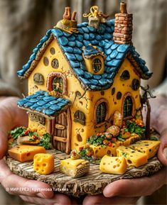 a person holding a small house made out of cheese