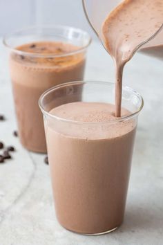 chocolate milk being poured into two glasses