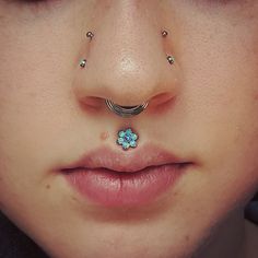 a woman with piercings on her nose and nose ring in the shape of a flower