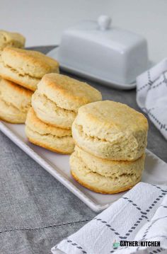 four biscuits on a white plate next to a napkin