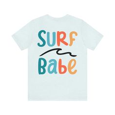 surf babe multi color font with line wave graphic.  surf style for surfer girl beach vacation summer outfit Casual Short Sleeve T-shirt For Water Sports, Blue Top For Summer Water Sports, Summer Water Sports Short Sleeve T-shirt, Casual Short Sleeve Tops For Water Sports, Surfing Graphic Tee With Screen Print, Graphic Surfing T-shirt With Screen Print, Graphic Tee With Screen Print For Surfing, Casual Beach T-shirt With Graphic Design, Casual Tops For Water Sports In Summer