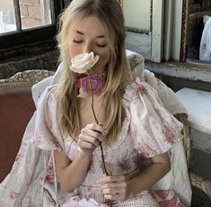 a woman sitting on a couch with a flower in her mouth