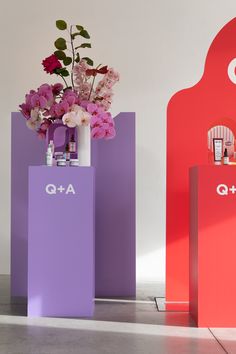 two vases with flowers in them sitting next to each other