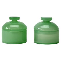 two green jars with lids on each one