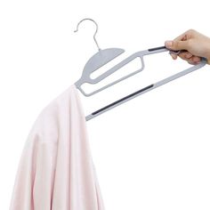 a person holding a clothes hanger over a pink shirt