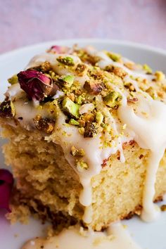 a piece of cake with white icing and nuts on it sitting on a plate