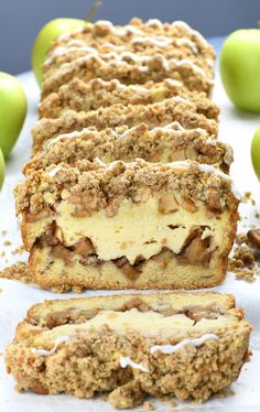 an apple crumb cake is cut in half and sitting on a table next to some green apples