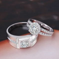 two wedding rings on top of each other with diamonds in the shants and sides