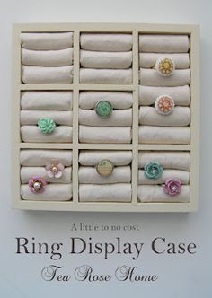 the ring display case is made out of white linens and has flowers on it