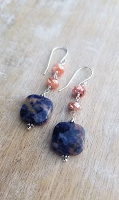 Sodalite Earrings Sterling Silver, Blue and Orange Earrings, Carnelian Earrings, Square Shaped Gemstone Dangle Earrings, Sunset Sodalite Dark indigo blue and orange sunset sodalite gemstones displaying lovely patterns dangle from mystic coated carnelian gemstones and sterling silver ear wires. The total length of the earrings is approximately 2 inches. The square orange sodalite gemstones are about 1/2 inch wide and 1/2 inch tall. They are faceted and polished on both sides. The blue and orange Agate Gemstone Dangle Earrings, Agate Gemstone Bead Dangle Earrings, Agate Gemstone Drop Earrings, Agate Dangle Earrings With Ear Wire, Sunset Sodalite, Blue Gemstone Earrings, Carnelian Earrings, Lapis Jewelry, Earrings Square