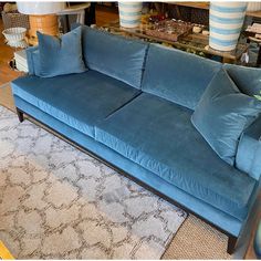 a blue couch sitting on top of a rug in a living room