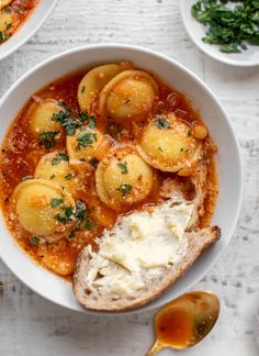 two bowls of stew with bread on the side