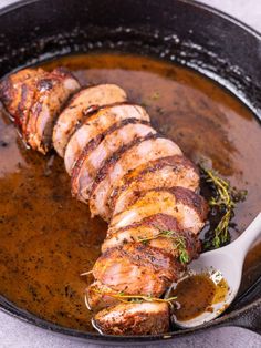 some meat is being cooked in a skillet