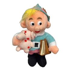 a stuffed doll holding a book in its hands