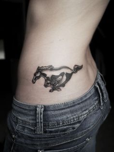 a woman's stomach with a horse tattoo on it