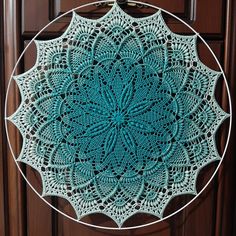 a circular doily hanging on a wooden door