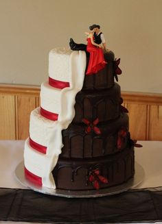 a wedding cake is decorated with chocolate and red ribbon