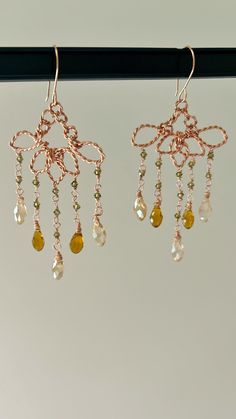 ✨✨Discover the elegance of our Lotus Flower Drop Earrings, a stunning addition to any outfit. Featuring a beautifully inverted lotus flower design, these earrings are adorned with delicate green crystals and amber drops. The combination of earthy tones and intricate craftsmanship creates a look that is both eye-catching and sophisticated. Made with copper wire, these earrings offer a touch of natural charm and a unique sparkle that is sure to turn heads. Perfect for adding a touch of elegance to Handmade Elegant Flower Crystal Earrings, Elegant Handmade Flower Crystal Earrings, Elegant Flower Shaped Chandelier Earrings, Elegant Handmade Teardrop Flower Earrings, Elegant Teardrop Flower Earrings For Jewelry Making, Handmade Rose Gold Flower Earrings, Handmade Elegant Rose Gold Flower Earrings, Elegant Handmade Rose Gold Flower Earrings, Elegant Wire Wrapped Flower Earrings