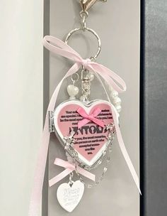 a pink heart shaped keychain hanging from a wall