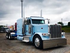 a blue semi truck parked in a parking lot