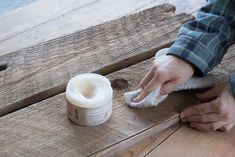 a person wiping off something on a wooden table