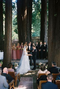 the bride and groom are getting married in front of their guests at this outdoor ceremony