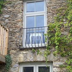 an open window on the side of a stone building