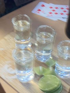 several glasses filled with water and limes on a table