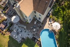 an aerial view of a house with a swimming pool and patio area in the foreground