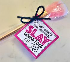 a pink and white sign sitting on top of a table next to a pencil holder