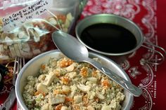 a bowl filled with rice and vegetables next to a cup of coffee on a table